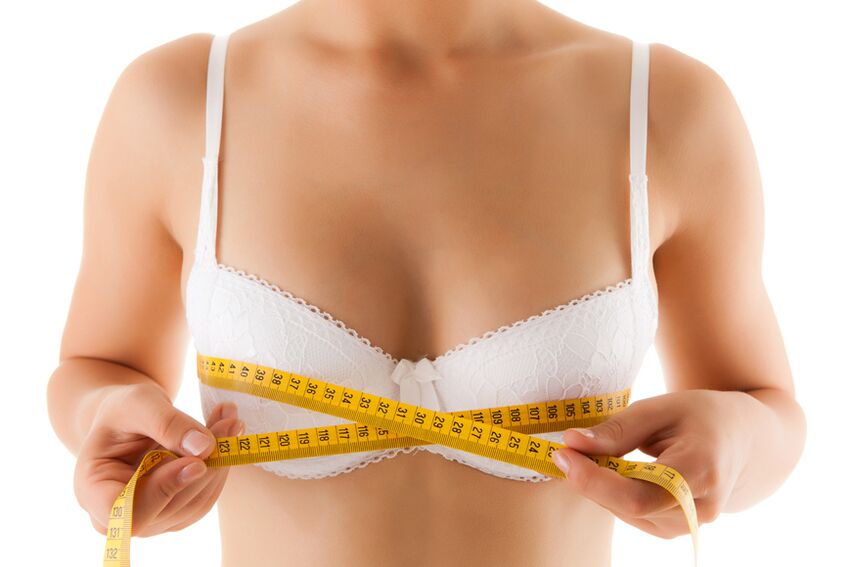 Una ragazza misura il suo seno, desiderando aumentarne le dimensioni